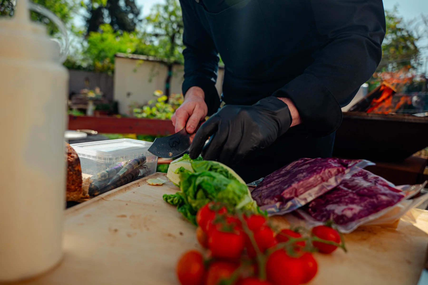 Ein Koch bereitet frische Zutaten direkt am Grill vor